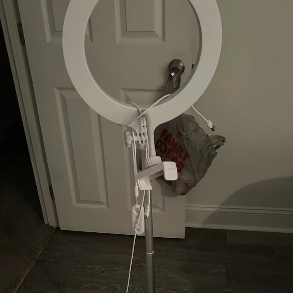 This is a standing ring light with a phone holder accessory with a remote also